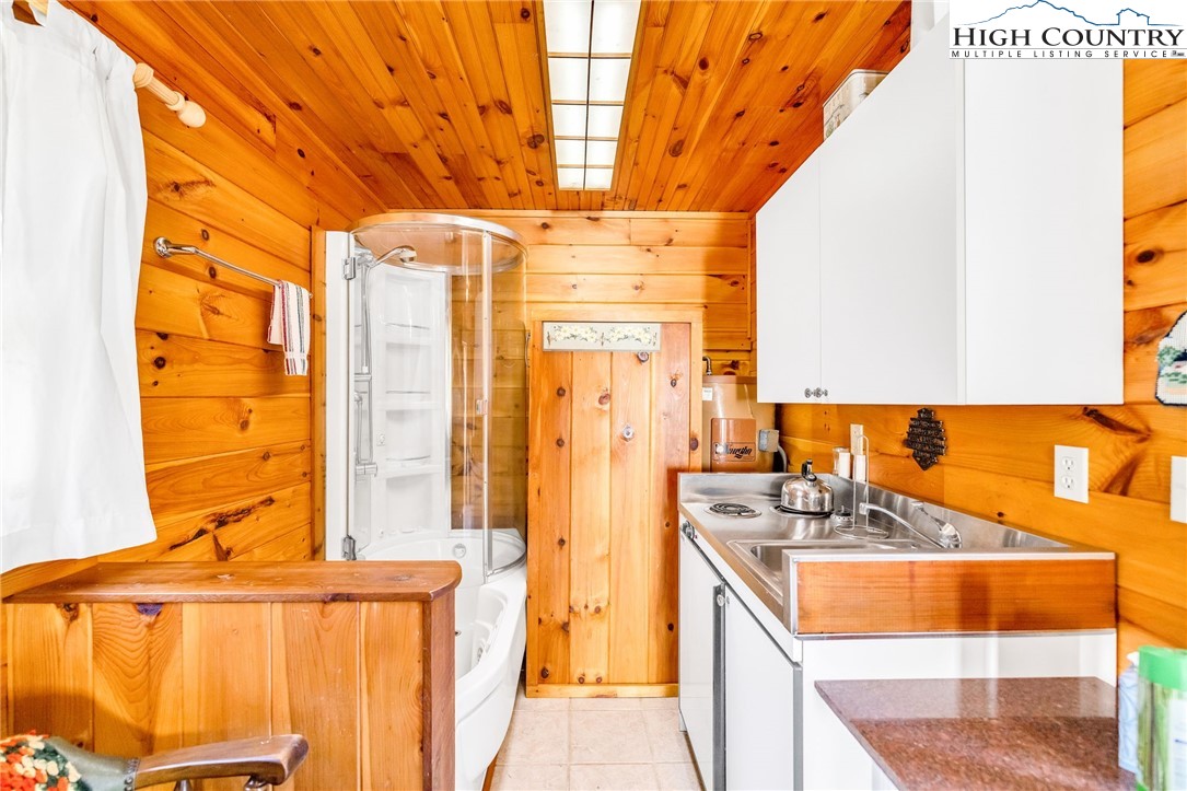1451 Elliott Road West Jefferson, NC 28694 - Photo 17 of 33 a kitchen with a sink a refrigerator and curtain