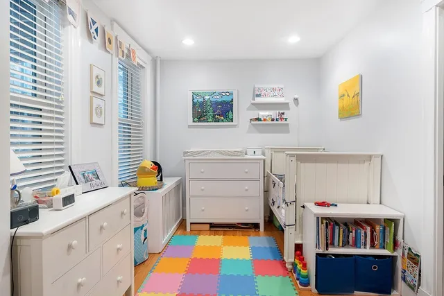 a bedroom with furniture a baby crib and a window