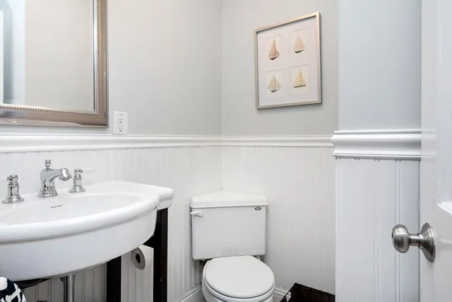 a bathroom with a toilet a sink and mirror
