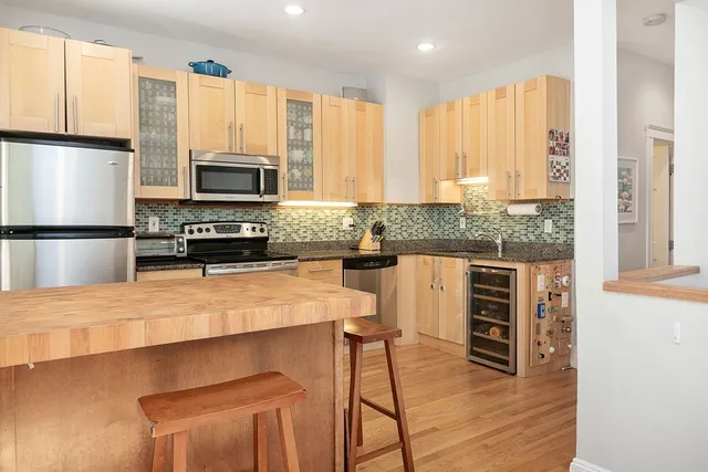 a kitchen with stainless steel appliances a stove sink microwave and cabinets
