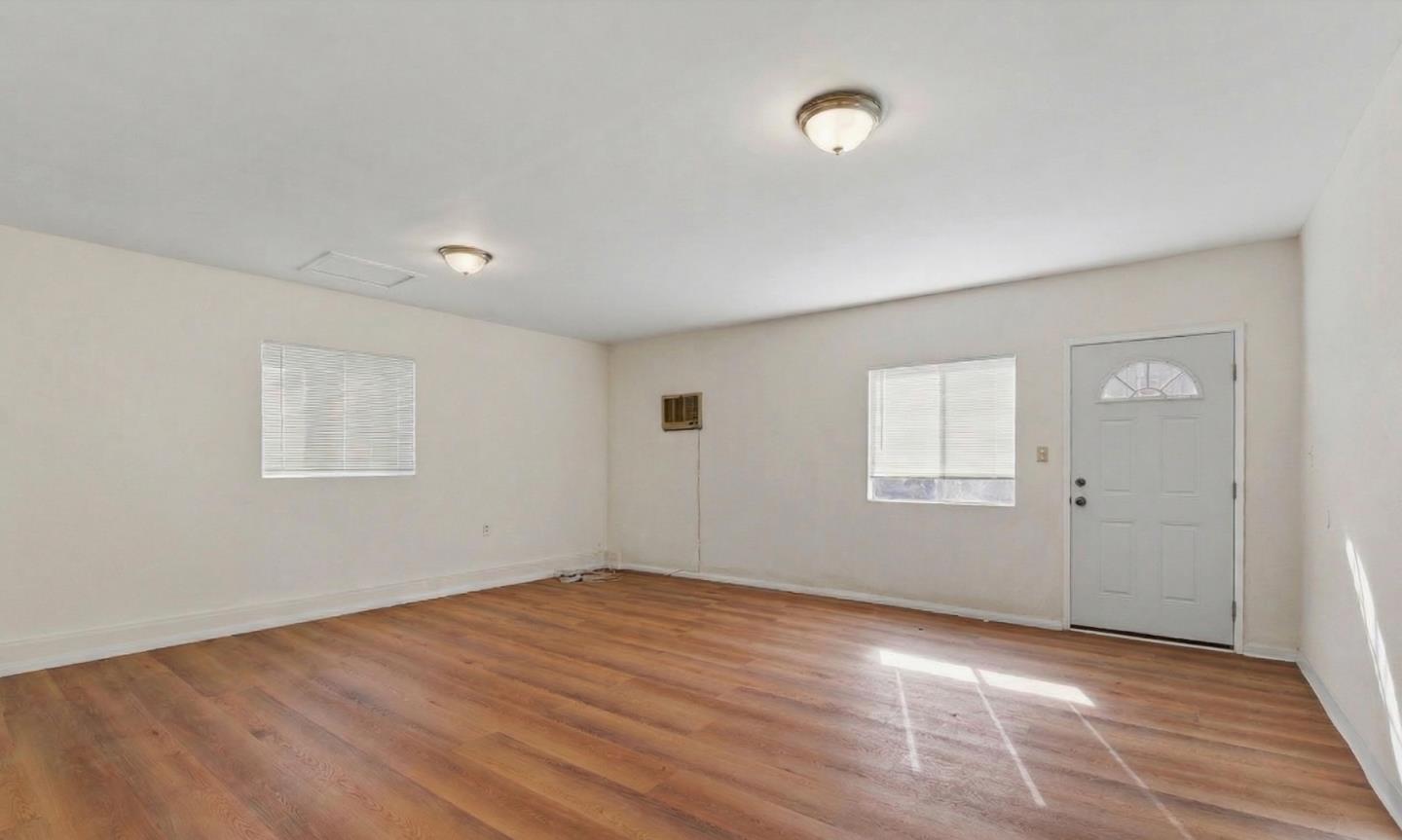 18601 Keswick Street, Unit B Reseda, CA 91335 - Photo 11 of 16 an empty room with wooden floor and windows