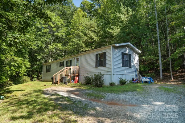 a view of a house with backyard and trees