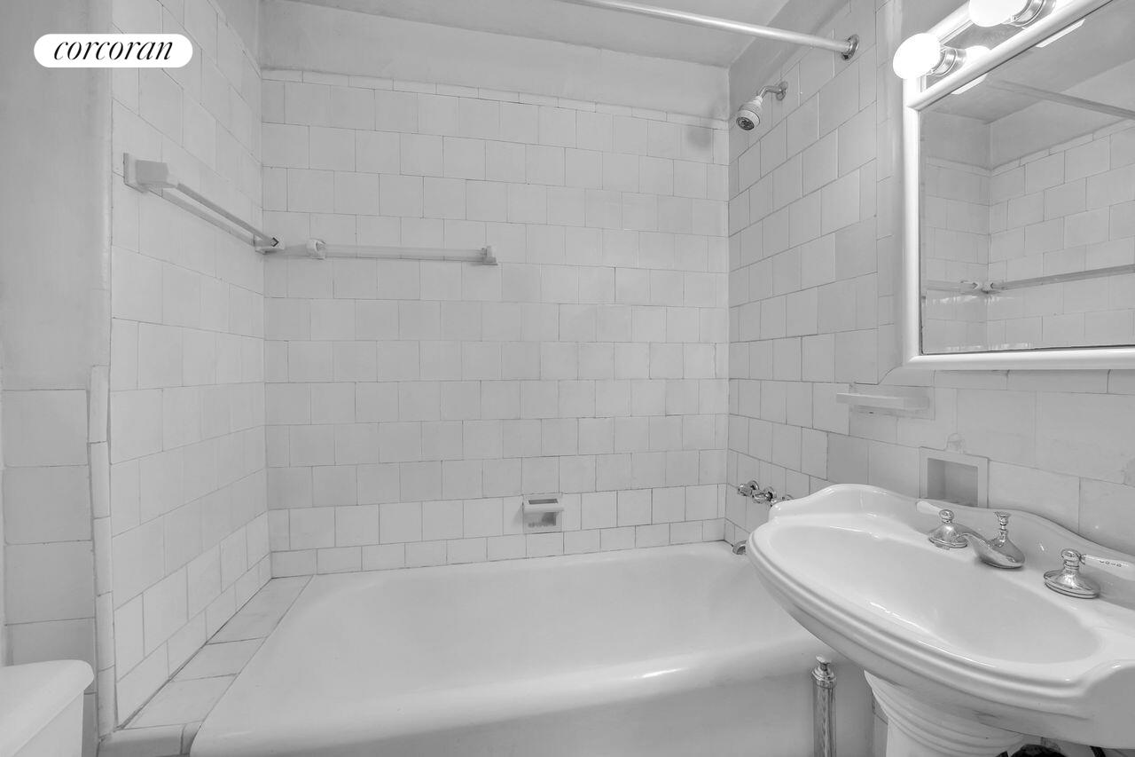 17 West 64th Street, Unit 2E Manhattan, NY 10023 - Photo 3 of 5 a white bath tub sitting next to a white sink and a shower