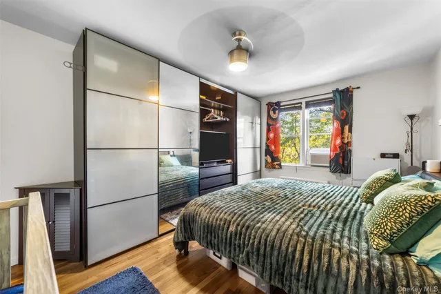 a bedroom with a bed and a large mirror on the dresser