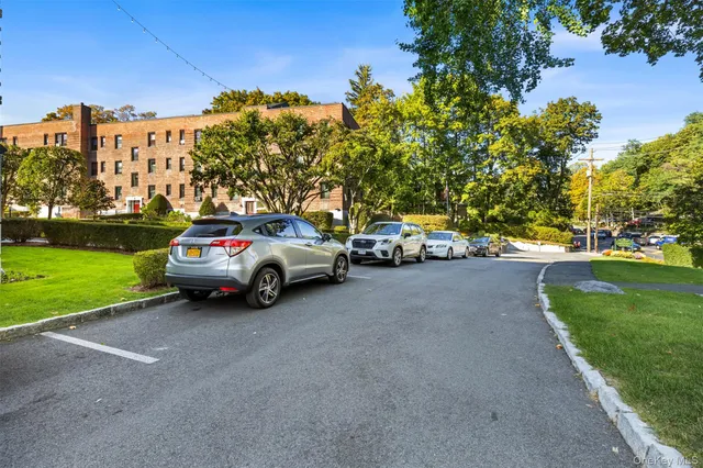 a view of a car parked in front of a house with a big yard