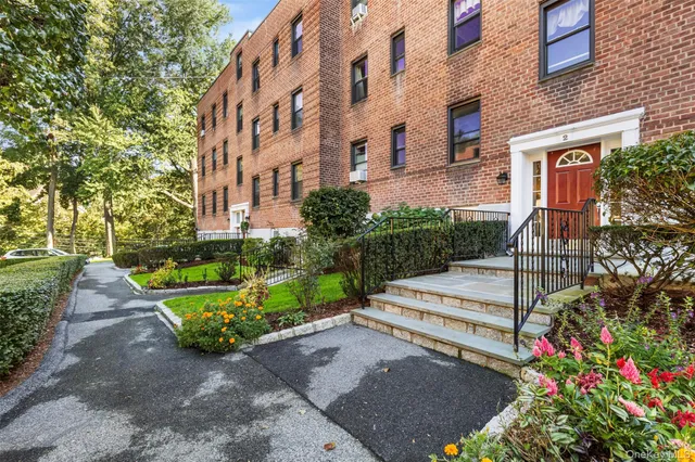 a view of a building with a garden and pathway