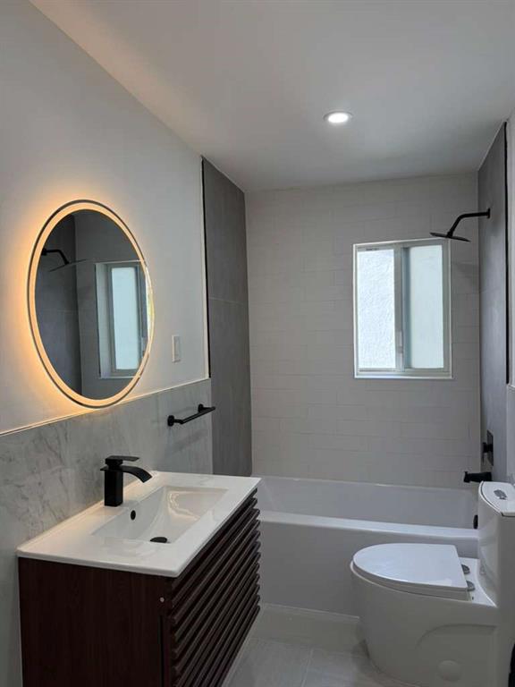 817 Tyler Street, Unit 8 Hollywood, FL 33019 - Photo 11 of 14 a bathroom with a bathtub a sink and a mirror