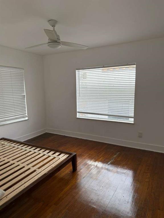 817 Tyler Street, Unit 8 Hollywood, FL 33019 - Photo 13 of 14 a view of an empty room with wooden floor and a window