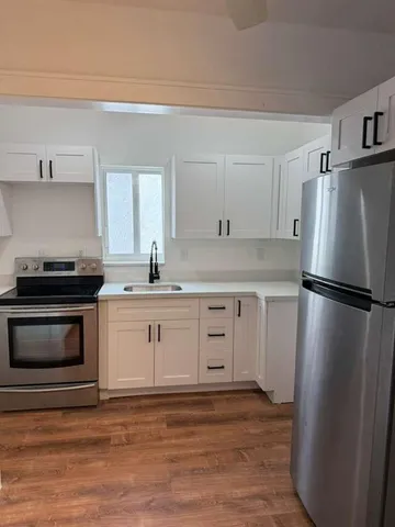 a kitchen with a refrigerator stove and white cabinets