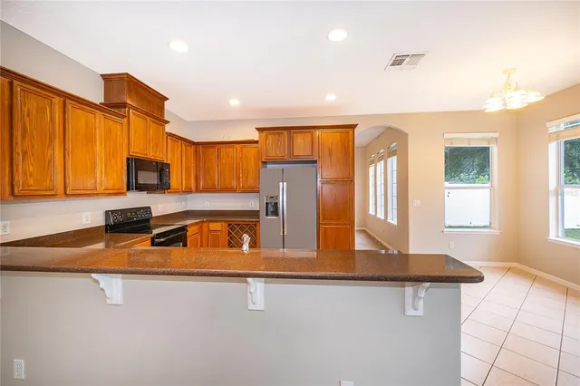 a kitchen with stainless steel appliances granite countertop a sink a stove and a refrigerator