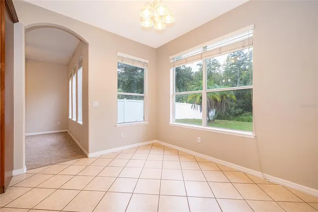 an empty room with windows and view of wooden floor