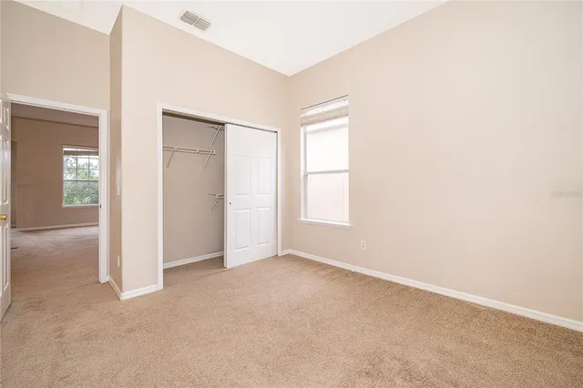 an empty room with windows and closet