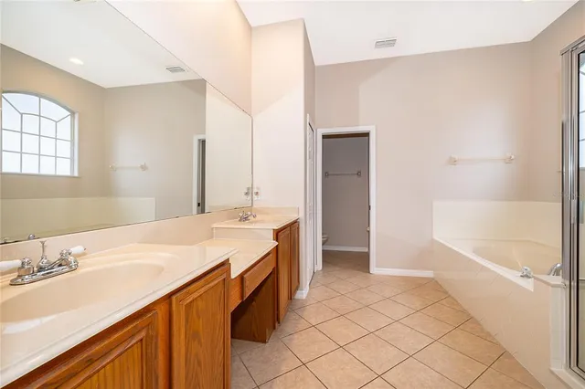 a spacious bathroom with a sink a mirror and a bathtub