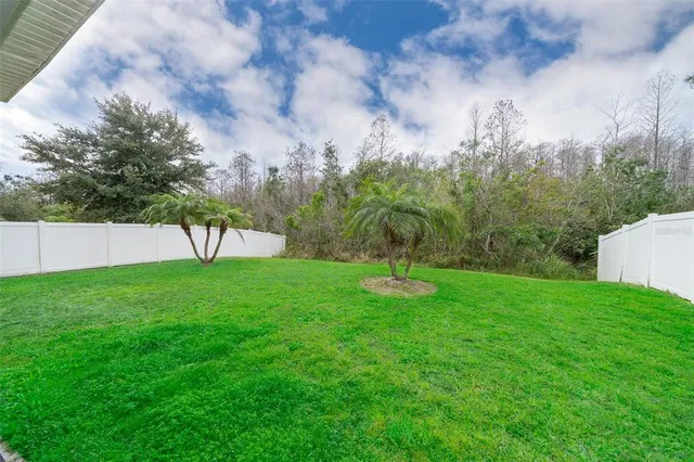 a view of green field with trees in the background