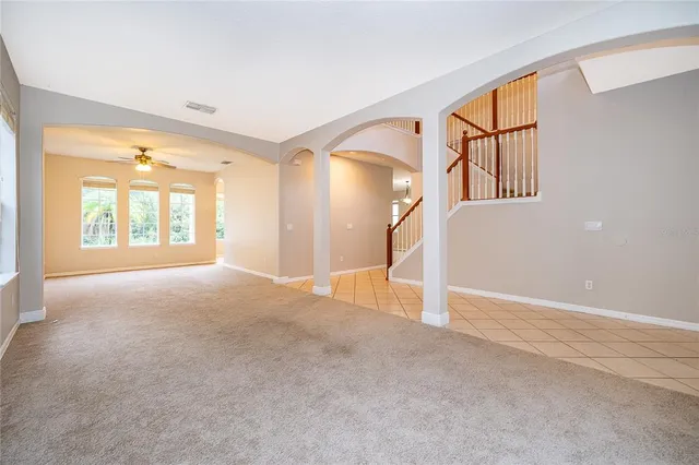 a view of a big room with windows and chandelier