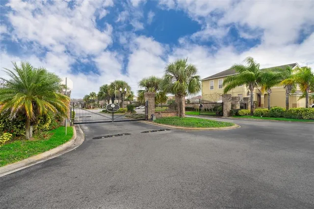 a view of a house with a big yard and palm trees