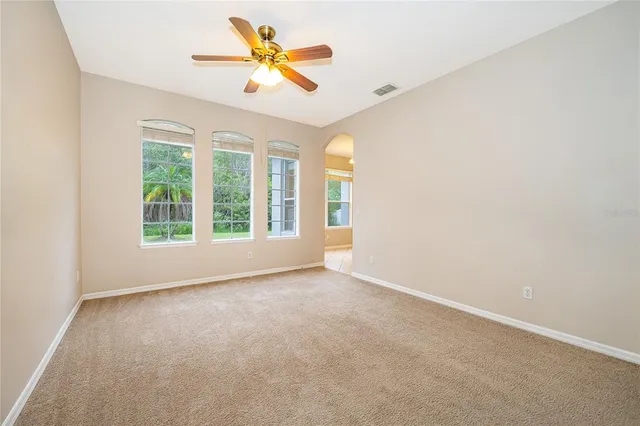 an empty room with a window and a ceiling fan