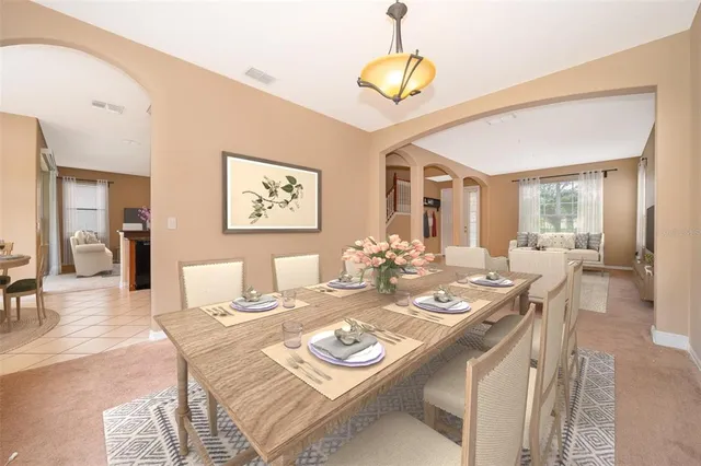 a dining room with wooden floor a chandelier a wooden table and chairs