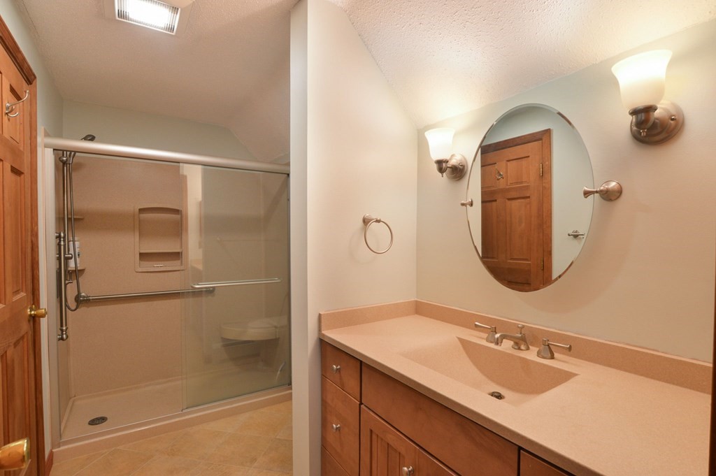 41 Braeside Road Falmouth, MA 02540 - Photo 15 of 24 a bathroom with a sink a mirror a vanity and shower