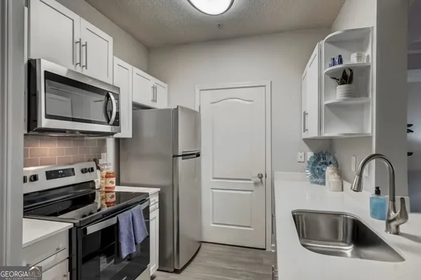 a kitchen with stainless steel appliances a refrigerator sink and microwave