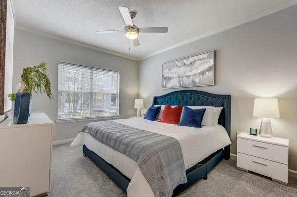 a spacious bedroom with a large bed and a chandelier