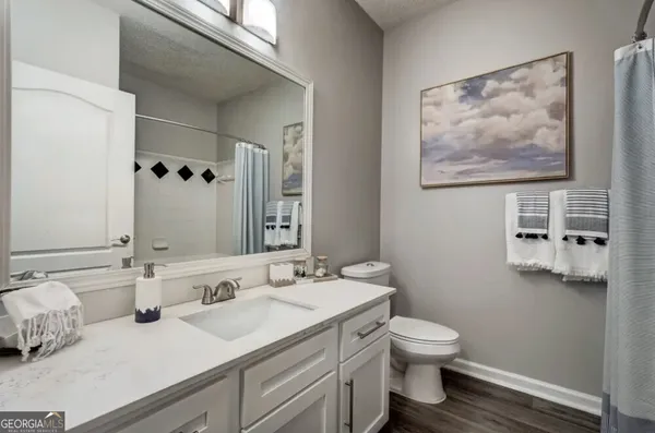 a bathroom with a granite countertop sink mirror and toilet