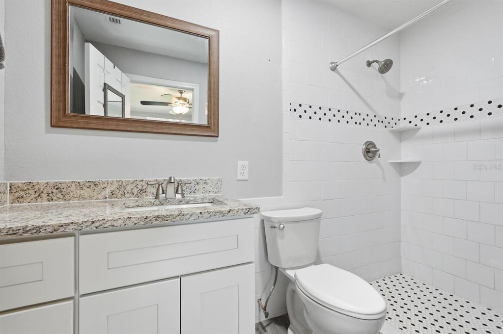 270 Wright Grove Road Oak Hill, FL 32759 - Photo 9 of 13 a bathroom with a granite countertop toilet sink and mirror