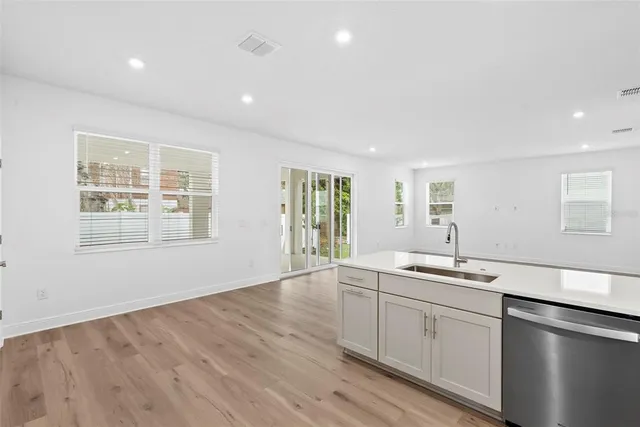 a view of a kitchen sink and wooden floor