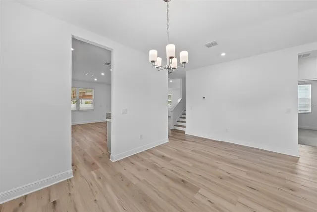 a view of a room with wooden floor and chandelier
