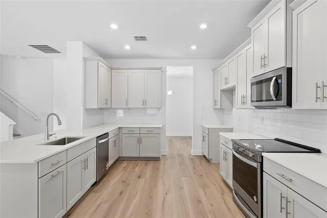 a kitchen with a sink stove top oven and cabinets