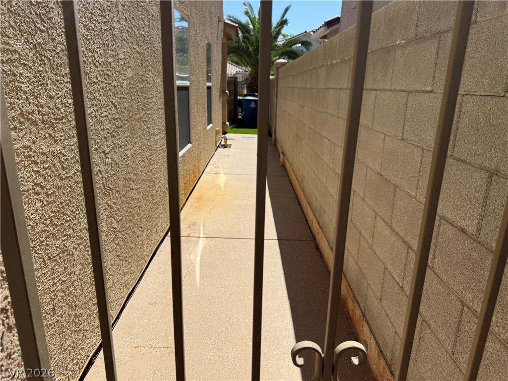 1141 Cathedral Ridge Street Henderson, NV 89052 - Photo 73 of 77 This outdoor walkway features stucco siding and a block wall, offering functional exterior space.