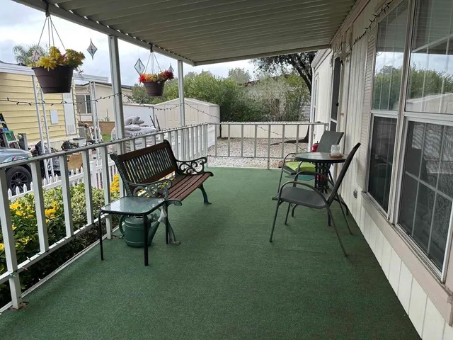 a view of a patio with table and chairs potted plants with floor to ceiling window