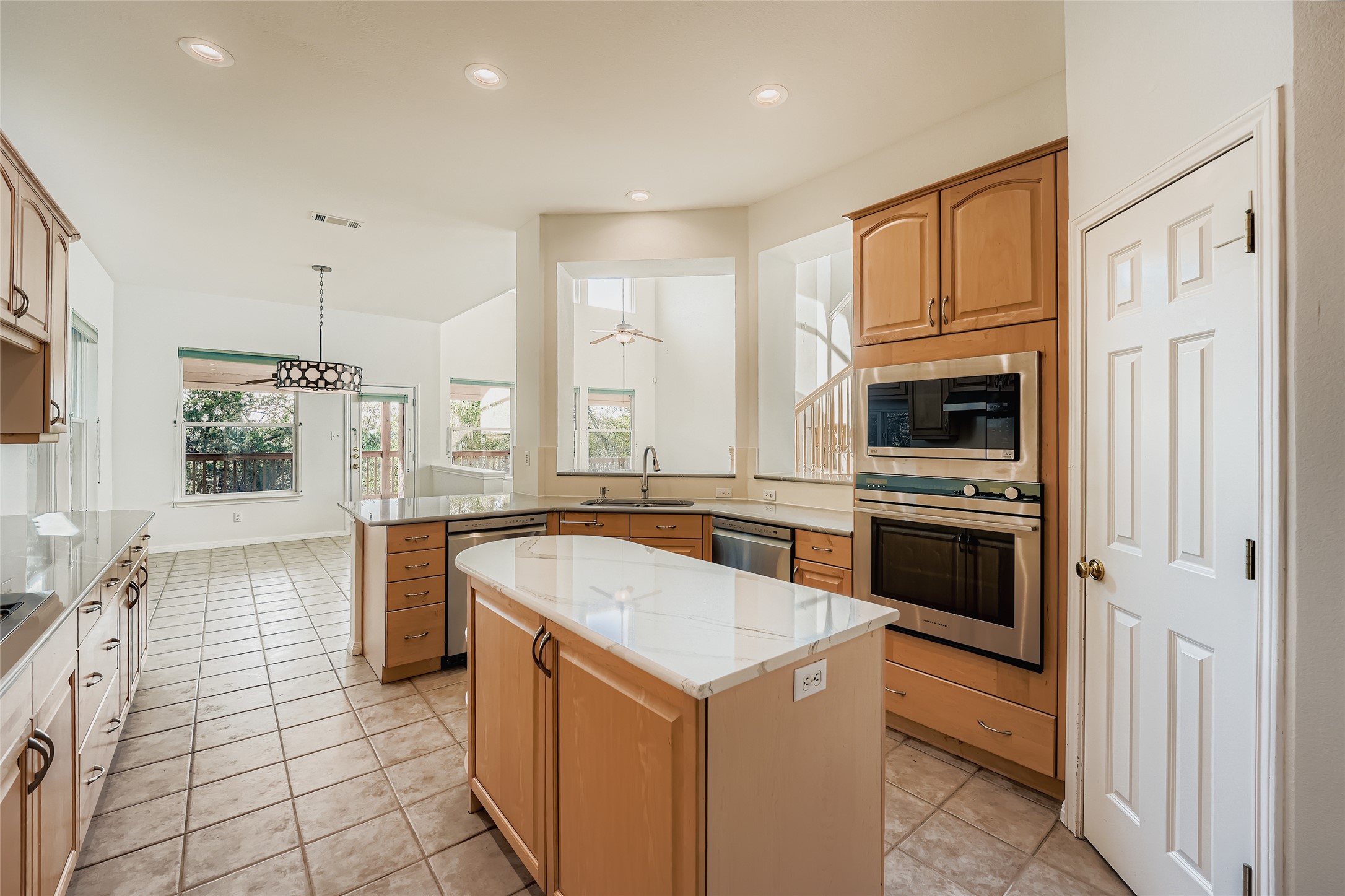 8204 Texas Plume Road Austin, TX 78759 - Photo 13 of 40 Kitchen featuring appliances with stainless steel finishes, a center island, hanging light fixtures, light tile patterned floors, and recessed lighting