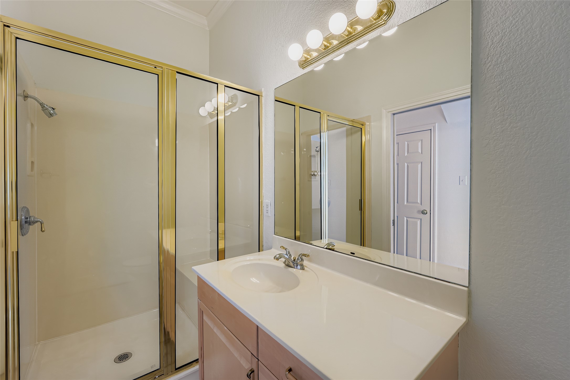 8204 Texas Plume Road Austin, TX 78759 - Photo 20 of 40 Bathroom with vanity, a stall shower, ornamental molding, and a textured wall