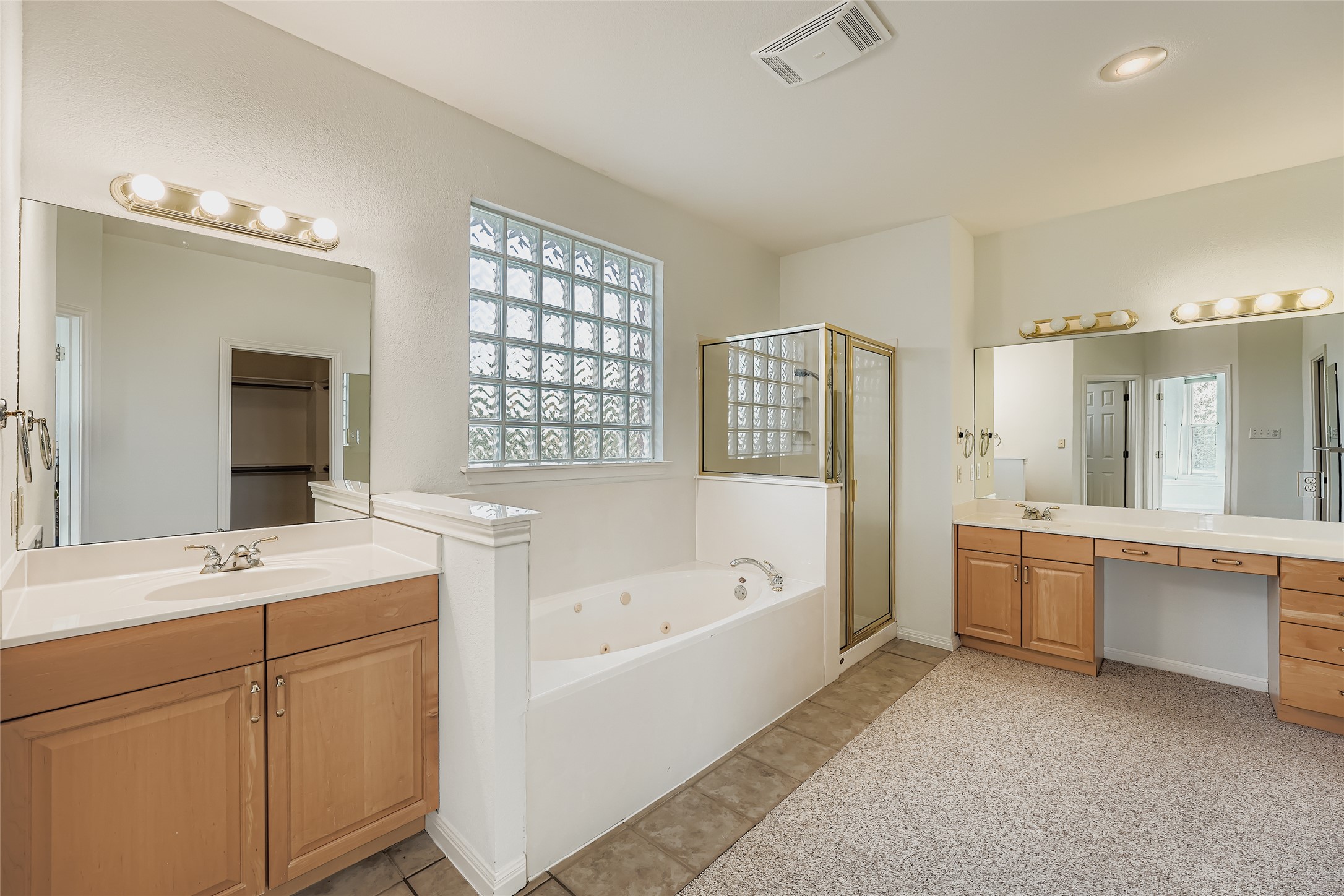 8204 Texas Plume Road Austin, TX 78759 - Photo 23 of 40 Full bath with a whirlpool tub, two vanities, a shower stall, light tile patterned flooring, and recessed lighting