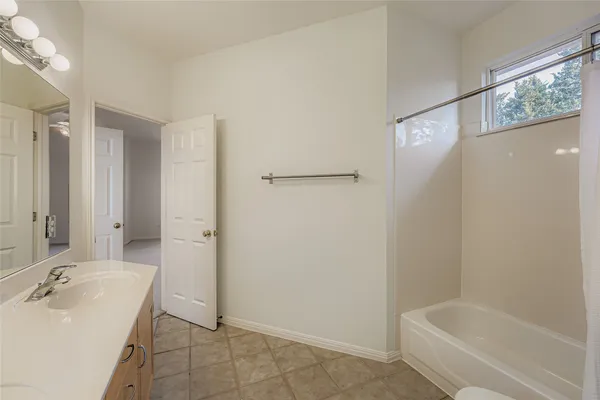 an empty room with a window and a ceiling fan