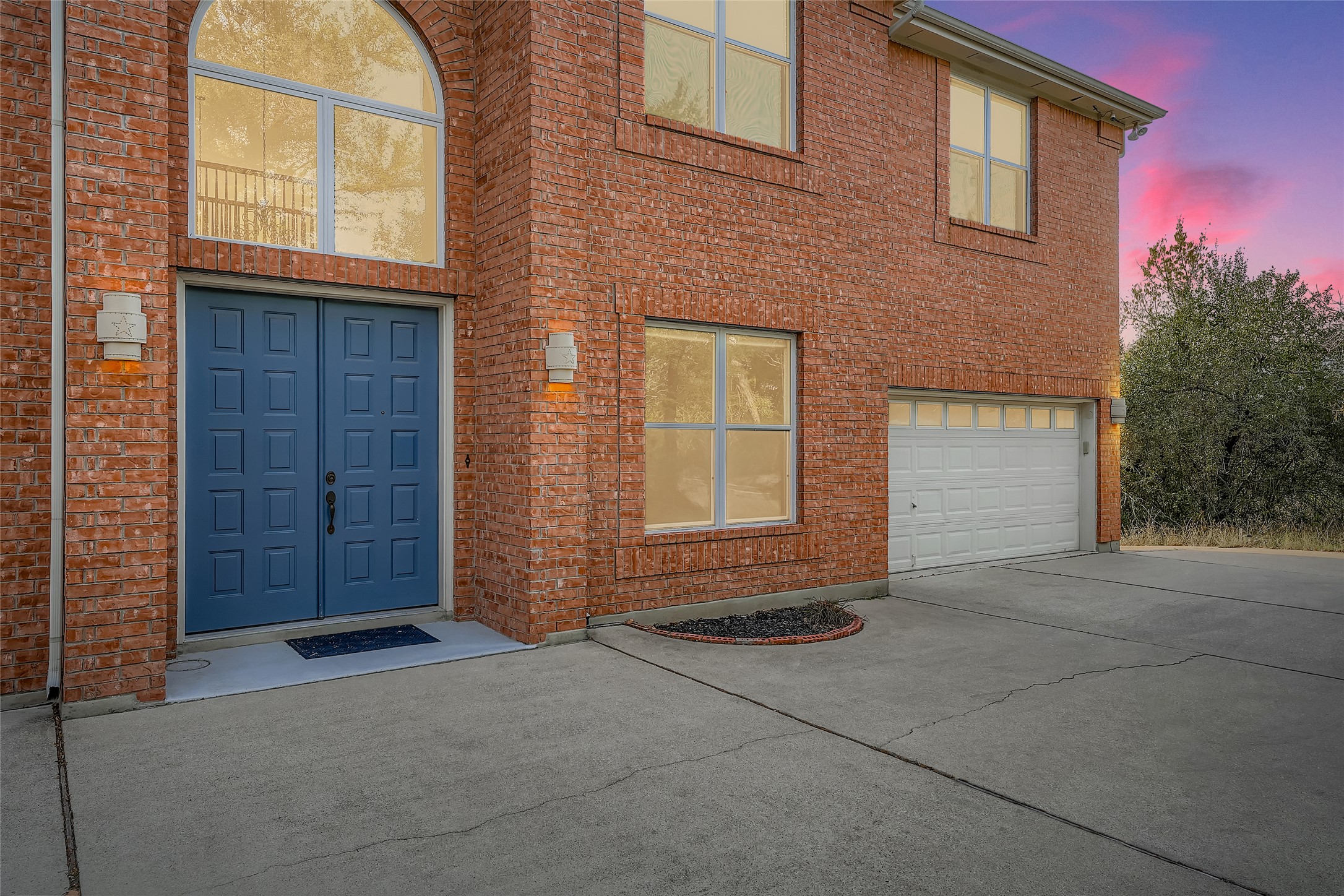 8204 Texas Plume Road Austin, TX 78759 - Photo 3 of 40 Property entrance featuring driveway, an attached garage, and brick siding