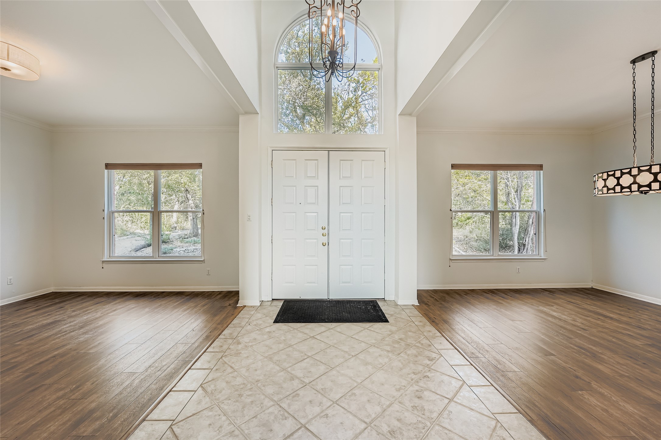 8204 Texas Plume Road Austin, TX 78759 - Photo 4 of 40 Entryway with wood-type flooring, a chandelier, healthy amount of natural light, a towering ceiling, and ornamental molding