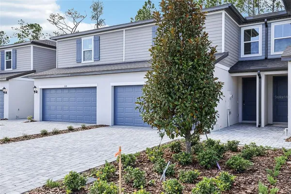 a front view of a house with a yard and a garage