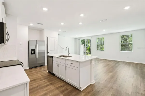 a kitchen with white cabinets and stainless steel appliances