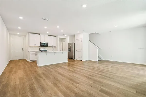 a view of kitchen with granite countertop cabinets and refrigerator