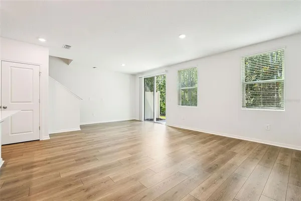 a view of a kitchen with wooden floor and electronic appliances