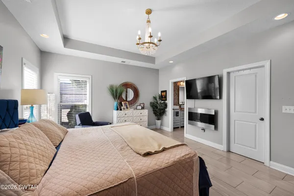a bedroom with a bed and a flat tv screen on dresser