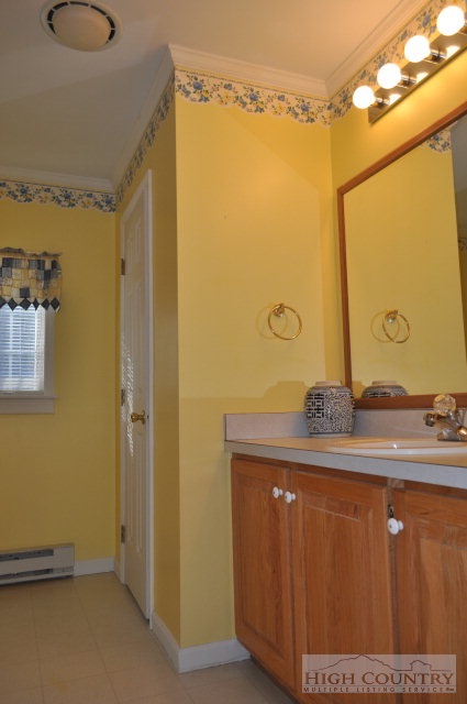 304 Green Knob Mountain Road Boone, NC 28607 - Photo 19 of 32 a bathroom with a granite countertop sink and a mirror