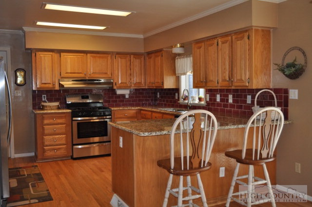 304 Green Knob Mountain Road Boone, NC 28607 - Photo 29 of 32 a view of a kitchen with stainless steel appliances granite countertop a stove a sink and a microwave
