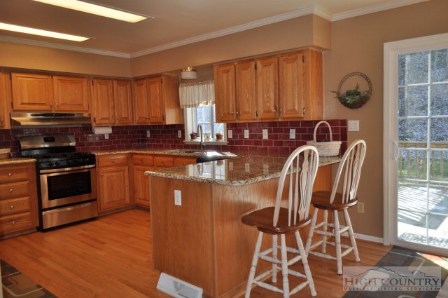 304 Green Knob Mountain Road Boone, NC 28607 - Photo 30 of 32 a kitchen with stainless steel appliances granite countertop a stove a sink dishwasher and a microwave oven with cabinets