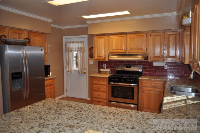 304 Green Knob Mountain Road Boone, NC 28607 - Photo 3 of 32 a kitchen with stainless steel appliances granite countertop a stove a refrigerator and a sink