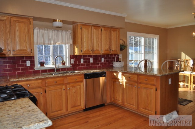304 Green Knob Mountain Road Boone, NC 28607 - Photo 31 of 32 a kitchen with stainless steel appliances granite countertop a sink stove and cabinets