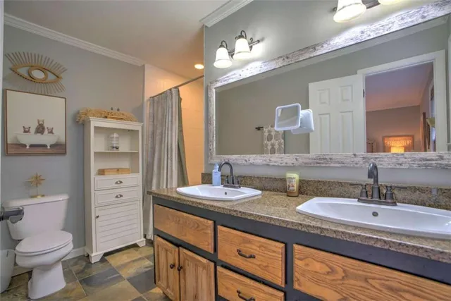 a bathroom with a granite countertop sink mirror and toilet