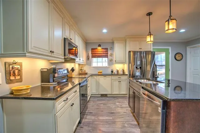 a kitchen with stainless steel appliances granite countertop a sink refrigerator and cabinets